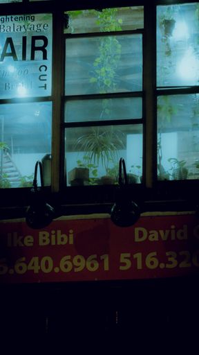 A vertical shot of a restaurant window in New York at night