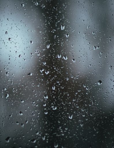 A vertical closeup of waterdrops of a blur glass great for backgrounds