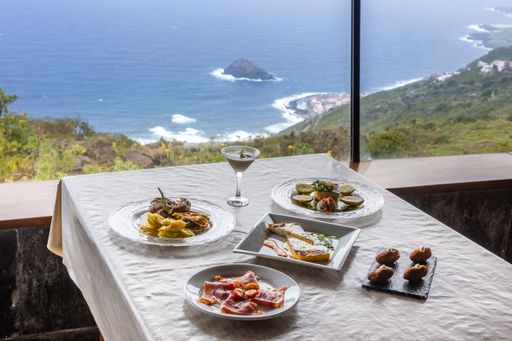 Various dishes on a restaurant table with a great view of a sea