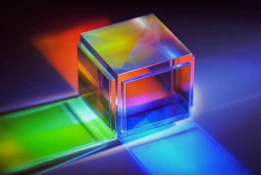 A closeup shot of dichroic reflective square cube scattering beam of light into several colors