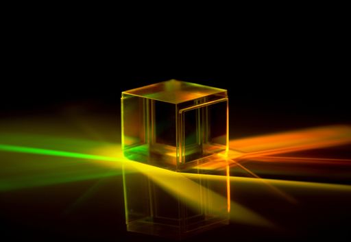 A closeup shot of dichroic reflective square cube scattering beam of light into several colors