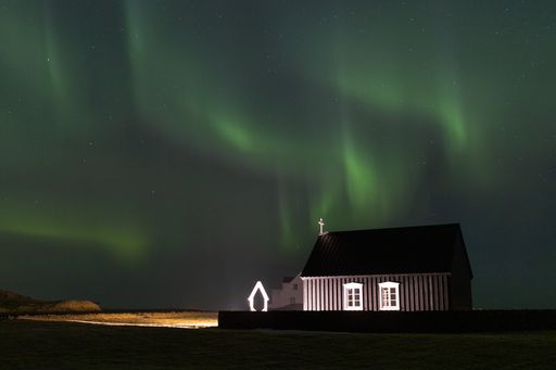 The beautiful Northern lights on the Reykjanes Skaginn Peninsula over the Black church in Iceland
