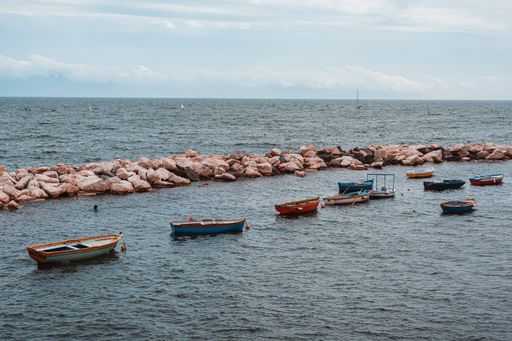 A beautiful view of the beach and small boats under the blue cloudy sky