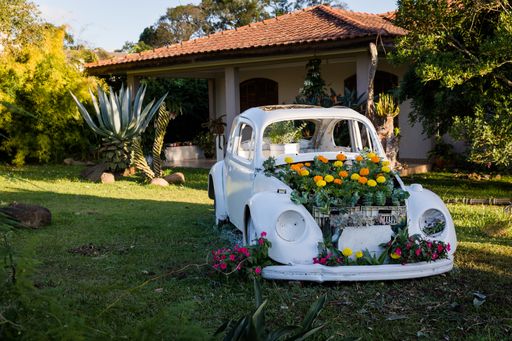 A beautiful shot of a white vintage car decorated with flowers in a garden