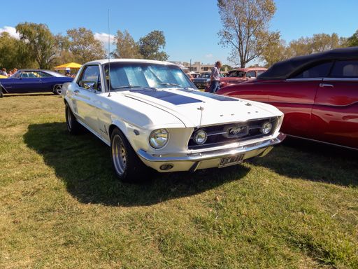 Chascomus, Argentina - Apr 9, 2022 - White sport muscle Ford Mustang 289 V8 coupe circa 1967 parked on the grass. Sunny day. Classic car show.