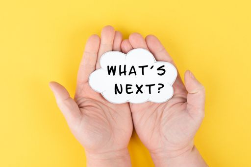 The phrase whats next is standing on a cloud shaped paper, having new goals and strategies, making plans for future