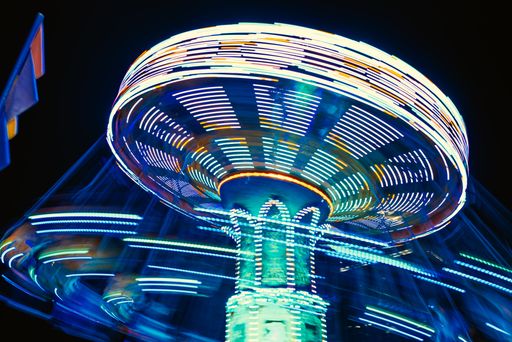 A carousel with bright lights of different colors in a rotary motion