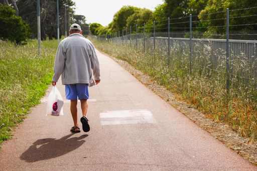 A man walking on a pavement during every day life task