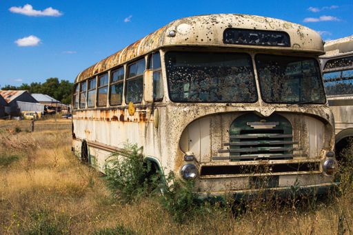 Abandoned rusty bus laying on a gras