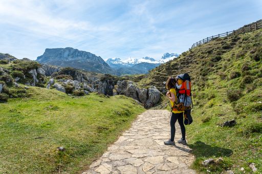 A back shot of a mother with her son heating to the Buferrera mines in the Covadonga lakes on a sunny day, Asturias, Spain
