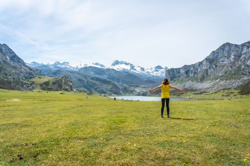 A back shot of an excited young woman visiting Lake Ercina in the Lakes of Covadonga. Asturias. Spain