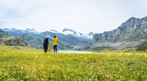 A back shot of a grandmother, mother and son sightseeing at Lake Ercina in the Lakes of Covadonga, Asturias, Spain