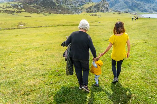 A back shot of a grandmother, mother and son sightseeing at Lake Ercina in the Lakes of Covadonga, Asturias, Spain