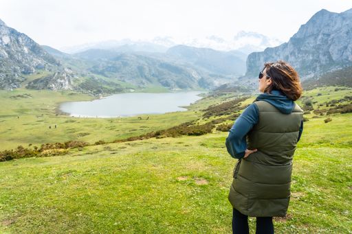 A back shot of a tourist with a backpack at the Entrelagos viewpoint of Lake Ercina in the Lakes of Covadonga, Asturias, Spain