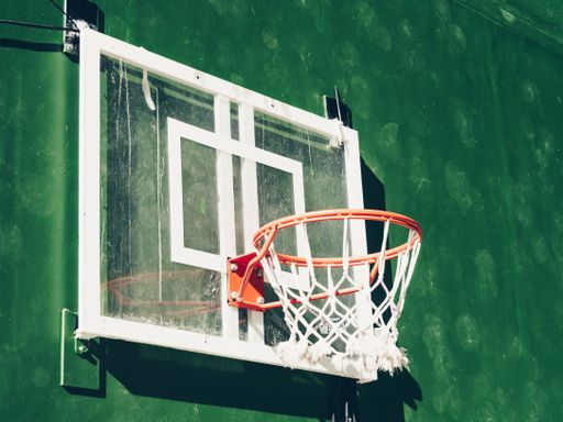 A closeup shot of basketball board and ring on a green background