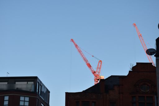 A scenery of urban buildings and new constructions with cranes in Manchester, England, the UK