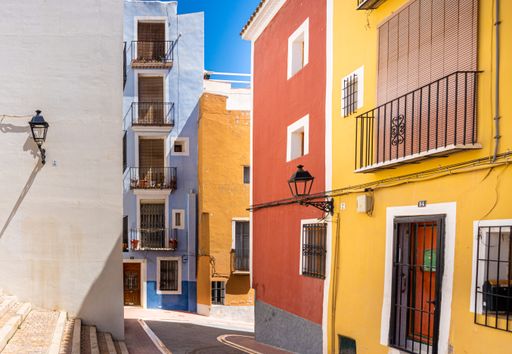 Typical houses and buildings, with facades painted in bright colors, on a sunny day. Villajoyosa, Alicante (Spain)