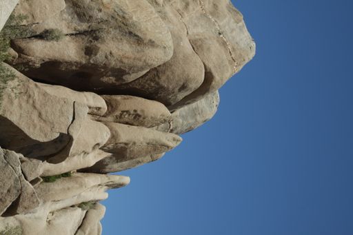 A vertical shot of big rock formation under blue bright sky