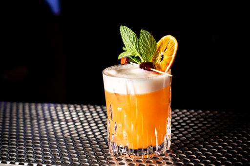 A closeup shot of a whiskey sour cocktail at a bar counter