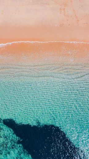 A beautiful aerial top view of sea waves washing the shore