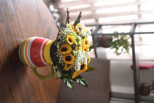 A vertical shot of a decorative vase with a sunflower bouquet on a dinner table