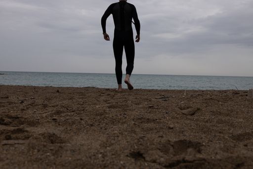 A man with diving suit seeking the sea for diving adventure under cloudy sky