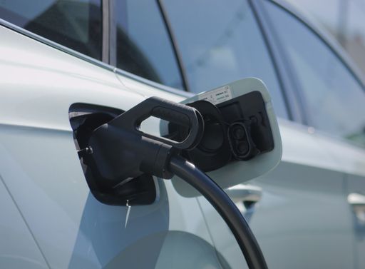 A closeup shot of an electric car being charged at a station