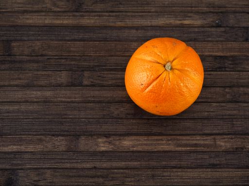 isolated orange on a wooden table, view from above