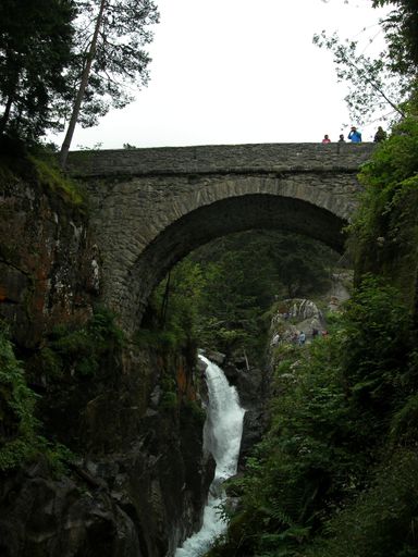 A stone bridge over a river in the mountains