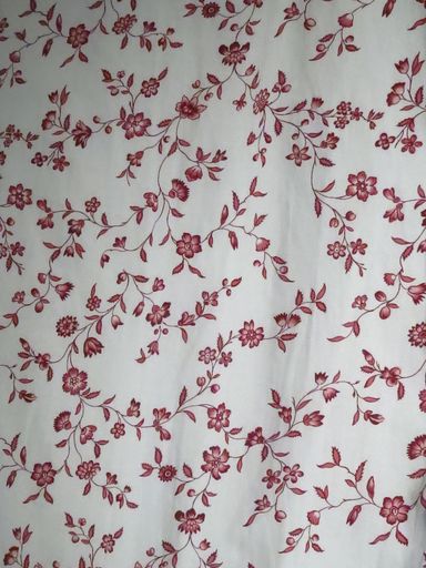 A vertical closeup shot of red floral patterns on a white textile