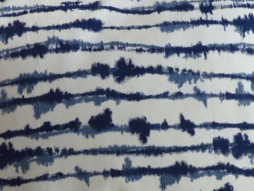 A closeup of tie-dye style blue stripes on white linen