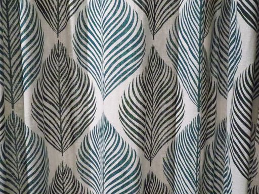 A closeup shot of large green black fern leaves pattern on a textile