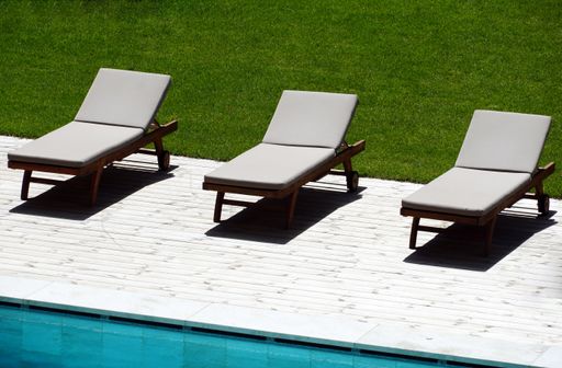A beautiful shot of three sun loungers near the pool