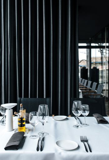 A vertical shot of a restaurant interior with an arranged empty table