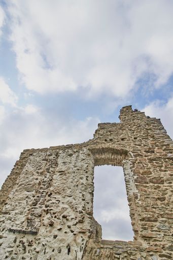 A low angle shot of arch Ruins of the Lowenburg castle in Monreal Eifel in Germany with a blue cloudy sky
