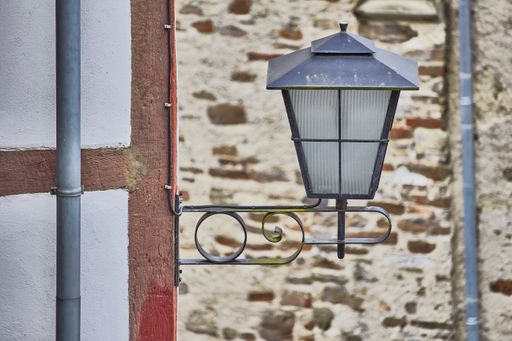 A beautiful shot of an old black street lantern hanging on a wooden wall in daylight in Monreal Municipality, Germany