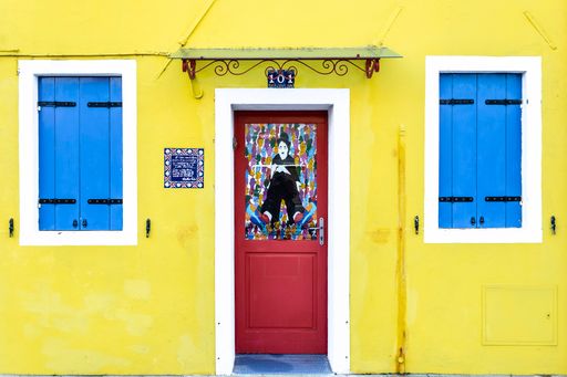 The facade of a beautiful colorful and small house with two blue windows