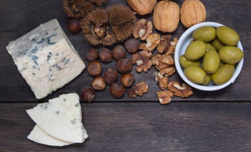 roquefort cheese with walnuts and olives on dark background