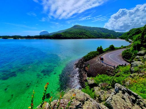 A scenic view of a calm coast and beautiful island under a clear sky during summer