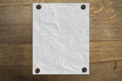 A closeup shot of a white paper on wooden table
