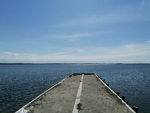 A beautiful view of a calm sea from a pier under the clear sky