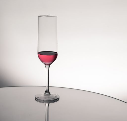 A drink in a glass cup with reflection on a mirror surface