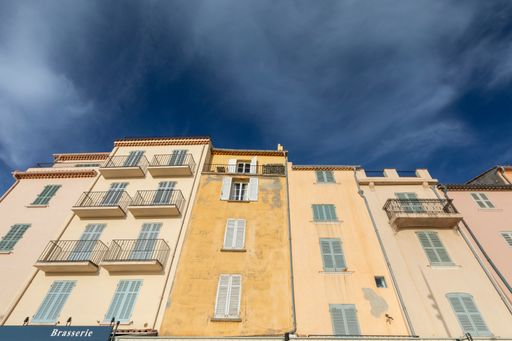 A low angle shot of residential buildings under a cloudy sky in Saint-Tropez, France