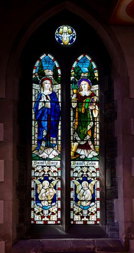 A vertical shot of stained glass windows in the Saint Winifred's Church Penrhiwceiber in Wales, the UK
