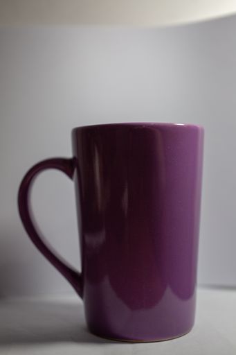 A vertical shot of a purple mug on a white surface