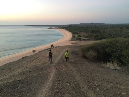 The two young men walking on sandy beach in East Nusa Tenggara, Indonesia