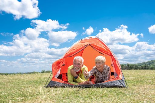 A couple lying in a tent in a field