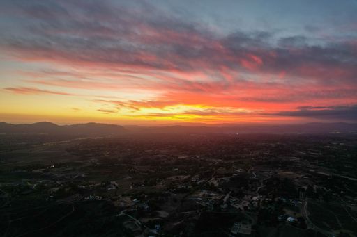 A bright orange pink sunset sky over the Los Angeles skyline