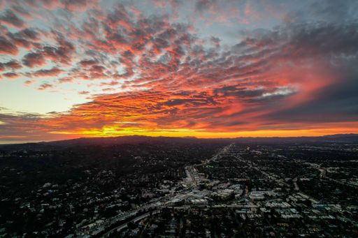 A bright orange pink sunset sky over the Los Angeles skyline