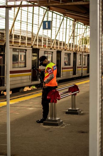 A vertical shot of a security guard on a Depok Railway Station, West Java